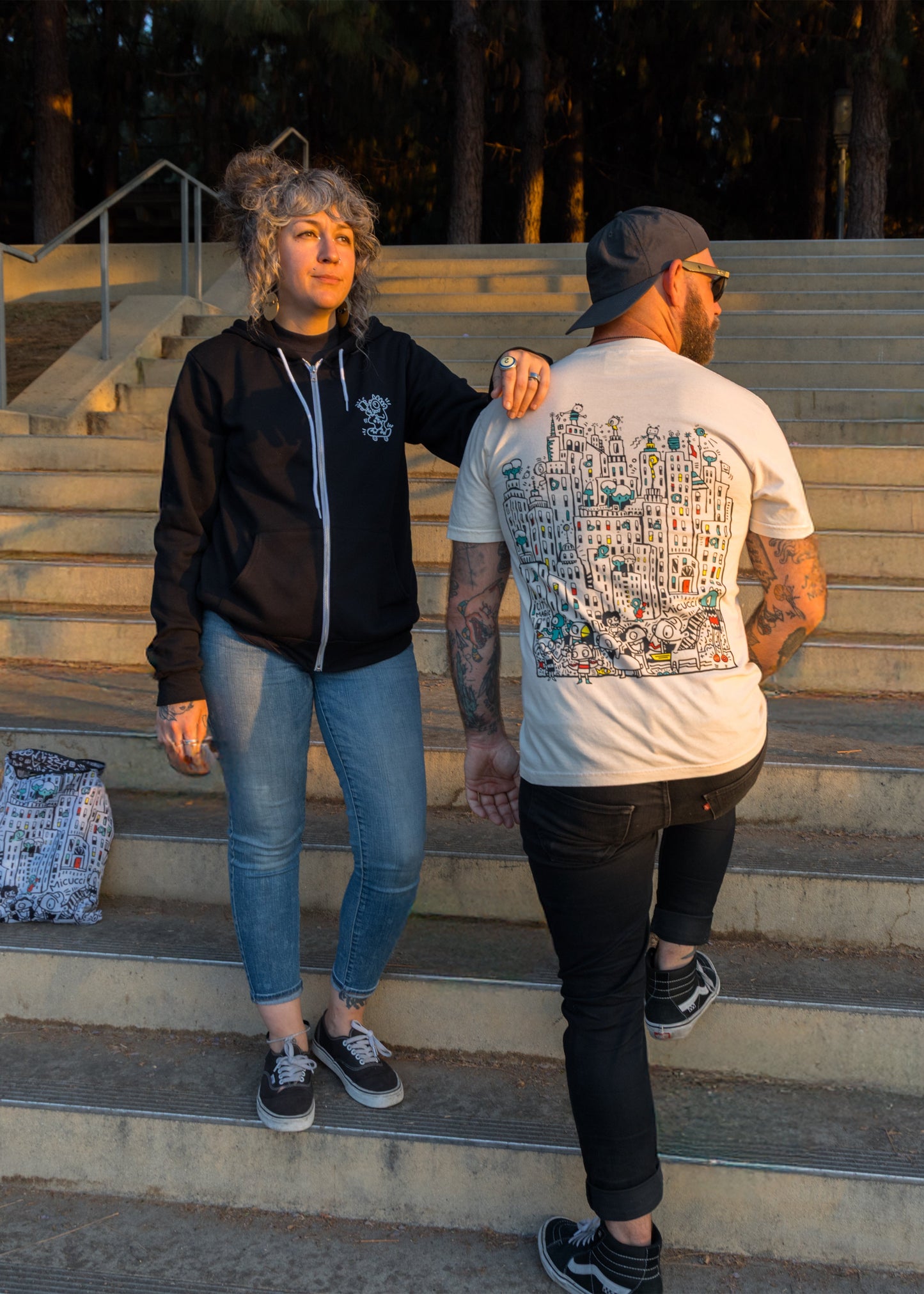 Two people standing on a set of outdoor stairs with trees in the background