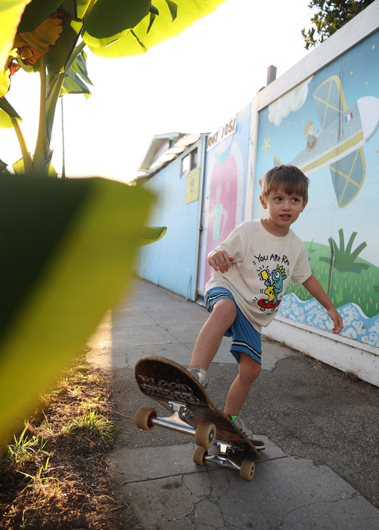 Child on a skateboard near a colorful mural