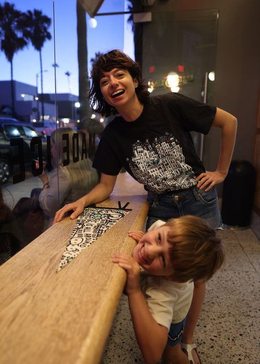 Two people leaning over a counter with a cityscape in the background