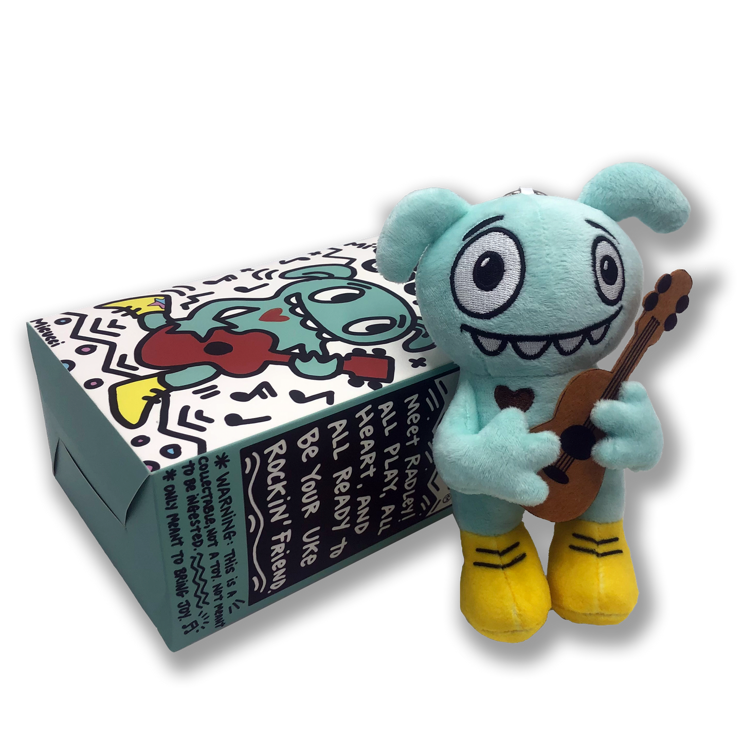 Plush toy character holding a guitar next to its packaging on a white background
